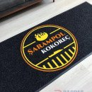 siyah zeminli sarı turuncu logolu paspas P5086