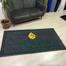 Siyah zeminli yeşil çerçeveli sarı logolu paspas P7332