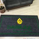 Siyah zeminli yeşil çerçeveli sarı logolu paspas P7332