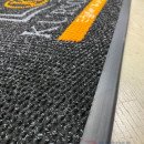 Siyah zeminli turuncu gri logolu paspas P7553